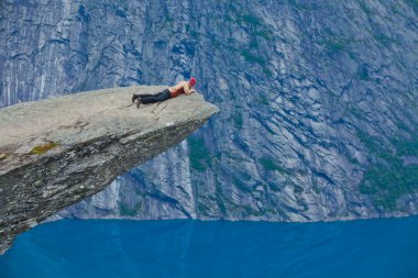 Yürüyüş yer - trolltunga, troller dil, bir turist ile kaya skjegedall ve göl ringedalsvatnet ve dağ panoramik manzara epik görünümü, Norveç ünlü Norveçli canlı bir resmini