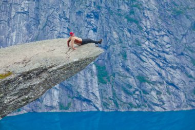 Yürüyüş yer - trolltunga, troller dil, bir turist ile kaya skjegedall ve göl ringedalsvatnet ve dağ panoramik manzara epik görünümü, Norveç ünlü Norveçli canlı bir resmini