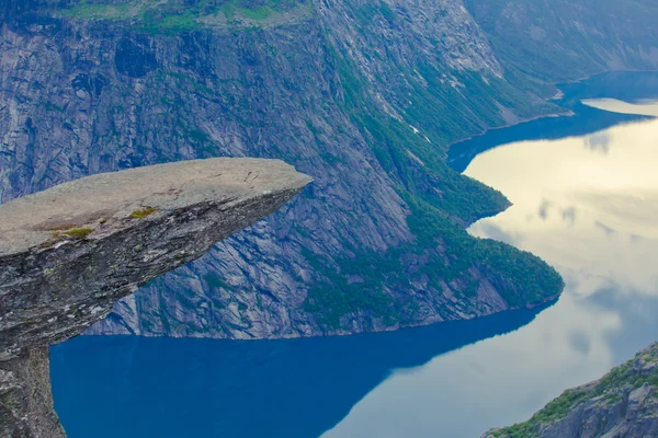 Een levendige beeld van beroemde Noorse wandelen plaats - trolltunga, de trollen tong, rots skjegedall, met een toerist, en weergave epische bij panoramische landschap van lake ringedalsvatnet en de bergen, Noorwegen — Stockfoto