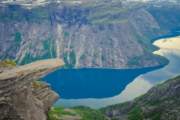 Une image vibrante de la célèbre place de randonnée nordique trolltunga, la langue trolls, rocher skjegedall, avec un touriste, et le lac ringedalsvatnet et vue panoramique sur le paysage de montagne épique, Norvège — Photo