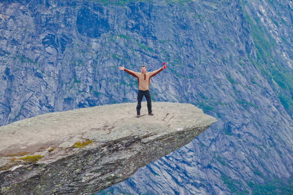 Яркая картина знаменитых норвежских мест для пеших прогулок - троллей, троллей, скал, скал, с туристом, а также озеро Рингедалсватнет и горный панорамный пейзаж, Норвегия
