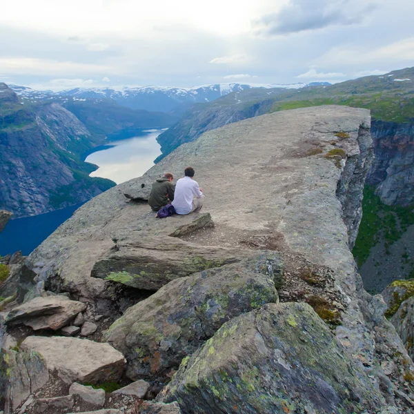 Pulzující obrázek slavných norské turistické místo - trolltunga, trollové jazyk, skalní skjegedall, s turista a jezera ringedalsvatnet a horské panoramatických scenérií epické pohled, Norsko — Stock fotografie