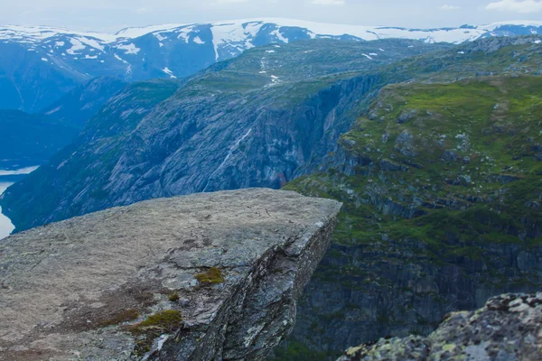Ein lebhaftes Bild des berühmten norwegischen Wandergebietes - Trolltunga, die Trollzunge, Rock skjegedall, mit einem Touristen, und See ringedalsvatnet und Bergpanorama epische Aussicht, Norwegen — Stockfoto