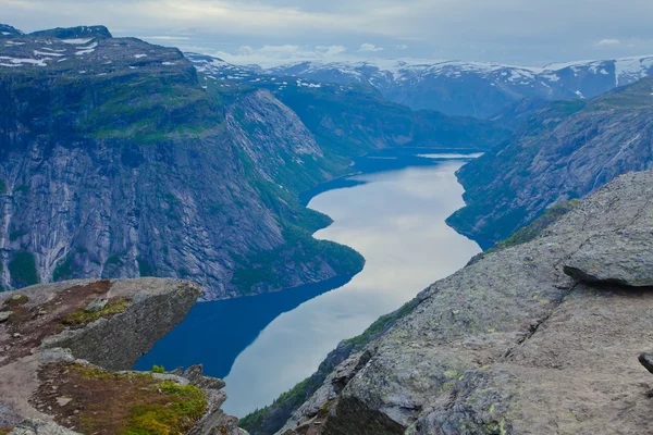 Ein lebhaftes Bild des berühmten norwegischen Wandergebietes - Trolltunga, die Trollzunge, Rock skjegedall, mit einem Touristen, und See ringedalsvatnet und Bergpanorama epische Aussicht, Norwegen — Stockfoto