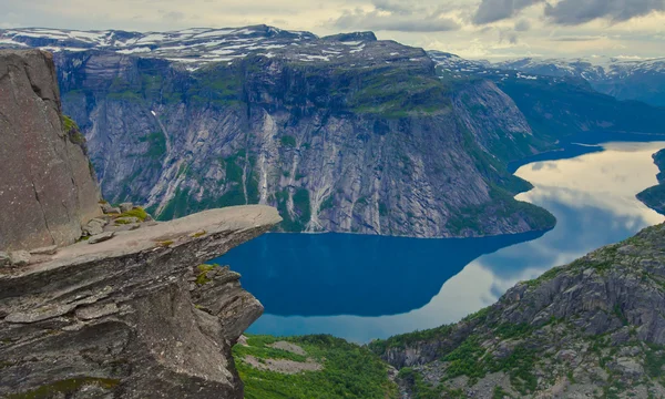 प्रसिद्ध नॉर्वेजियन हायकिंग ठिकाणांचे एक जीवंत चित्र ट्रोल्टुंगा, ट्रोल जीभ, रॉक स्केगेडॉल, एक पर्यटक आणि लेक रिंगडल्सवेटनेट आणि डोंगराळ पॅनोरॅमिक दृश्य एपिक दृश्य, नॉर्वे — स्टॉक फोटो, इमेज