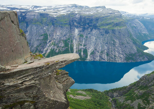 Яркая картина знаменитых норвежских мест для пеших прогулок - троллей, троллей, скал, скал, с туристом, а также озеро Рингедалсватнет и горный панорамный пейзаж, Норвегия
