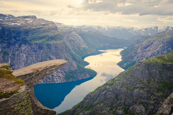 Una imagen vibrante del famoso lugar de senderismo noruego - trolltunga, la lengua trolls, roca skjegedall, con un turista, y el lago ringedalsvatnet y paisajes panorámicos de montaña vista épica, Noruega — Foto de Stock