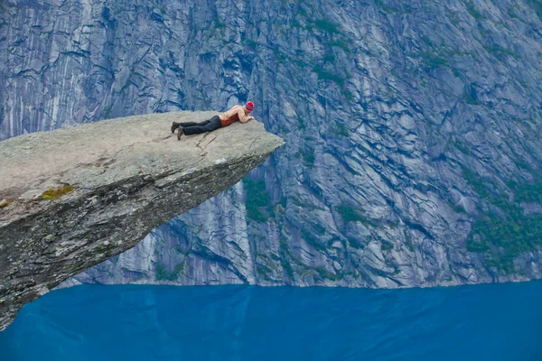 A vibrant picture of famous norwegian hiking place - trolltunga, the trolls tongue, rock skjegedall, with a tourist, and lake ringedalsvatnet and mountain panoramic scenery epic view, Norway — Stock Photo, Image