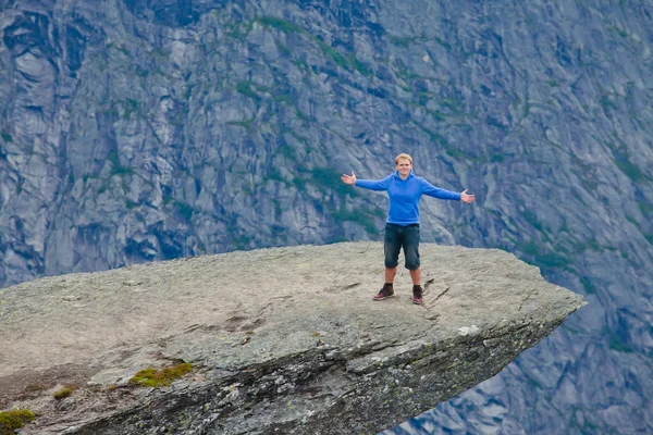 A vibrant picture of famous norwegian hiking place - trolltunga, the trolls tongue, rock skjegedall, with a tourist, and lake ringedalsvatnet and mountain panoramic scenery epic view, Norway — Stock Photo, Image