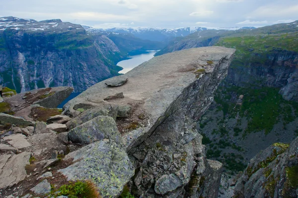 A vibrant picture of famous norwegian hiking place - trolltunga, the trolls tongue, rock skjegedall, with a tourist, and lake ringedalsvatnet and mountain panoramic scenery epic view, Norway — Stock Photo, Image