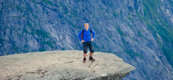 A vibrant picture of famous norwegian hiking place - trolltunga, the trolls tongue, rock skjegedall, with a tourist, and lake ringedalsvatnet and mountain panoramic scenery epic view, Norway — Stock Photo, Image