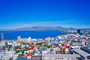 Güzel süper geniş açı havadan görünümü Reykjavik, İzlanda'nın liman ve manzarası dağlar ve şehrin ötesinde gözlem tanımlıkHallgrimskirkja katedral Kulesi gördün.