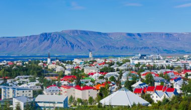 Güzel süper geniş açı havadan görünümü Reykjavik, İzlanda'nın liman ve manzarası dağlar ve şehrin ötesinde gözlem tanımlıkHallgrimskirkja katedral Kulesi gördün.
