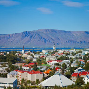 Güzel süper geniş açı havadan görünümü Reykjavik, İzlanda'nın liman ve manzarası dağlar ve şehrin ötesinde gözlem tanımlıkHallgrimskirkja katedral Kulesi gördün.