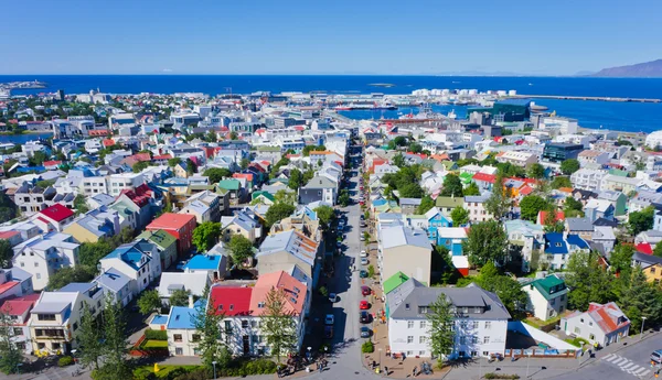 Bella vista aerea super grandangolare di Reykjavik, Islanda con montagne portuali e skyline e paesaggi oltre la città, visto dalla torre di osservazione della Cattedrale di Hallgrimskirkja . — Foto Stock