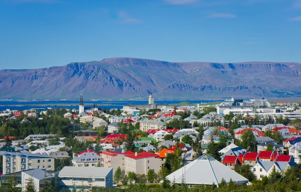 Gyönyörű szuper nagy látószögű légi felvétel a Reykjavik, Izland-kikötő és a skyline a hegyek és a táj túl a város látható a megfigyelő torony a Hallgrimskirkja székesegyház. — Stock Fotó