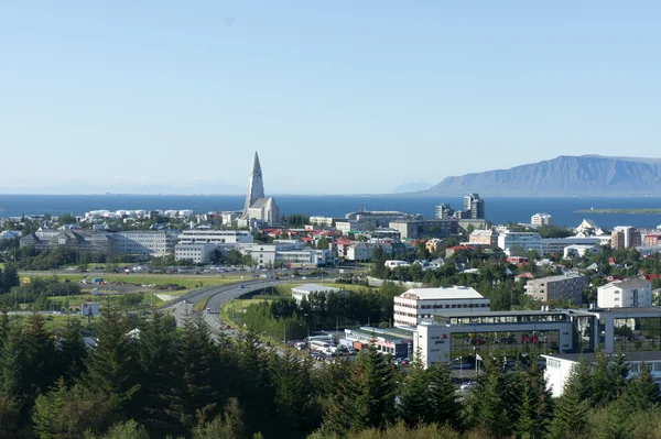 Hermosa vista aérea super gran angular de Reykjavik, Islandia, con el puerto y el horizonte montañas y paisajes más allá de la ciudad, visto desde la torre de observación de la catedral de Hallgrimskirkja . — Foto de Stock