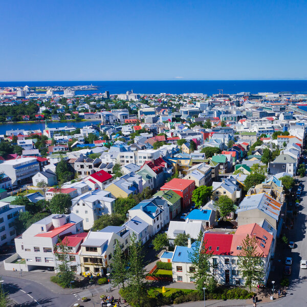 Beautiful super wide-angle aerial view of Reykjavik, Iceland with harbor and skyline mountains and scenery beyond the city, seen from the observation tower of Hallgrimskirkja Cathedral.