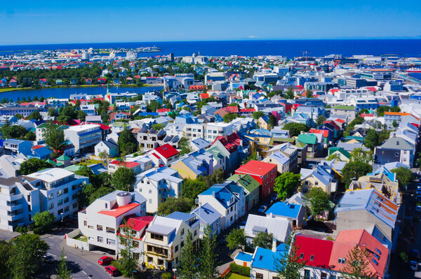 Beautiful super wide-angle aerial view of Reykjavik, Iceland with harbor and skyline mountains and scenery beyond the city, seen from the observation tower of Hallgrimskirkja Cathedral.