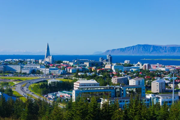 Beautiful super wide-angle aerial view of Reykjavik, Iceland with harbor and skyline mountains and scenery beyond the city, seen from the observation tower of Hallgrimskirkja Cathedral. — Stock Photo, Image