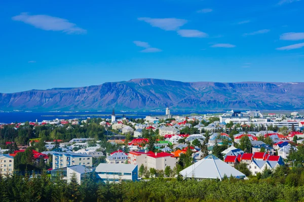 Όμορφη έξοχος Αεροφωτογραφία του Ρέικιαβικ, Ισλανδία με λιμάνι και στον ορίζοντα τα βουνά και τοπίο πέρα από την πόλη, που φαίνεται από την παρατήρηση πύργο της Hallgrimskirkja καθεδρικό ναό. — Φωτογραφία Αρχείου