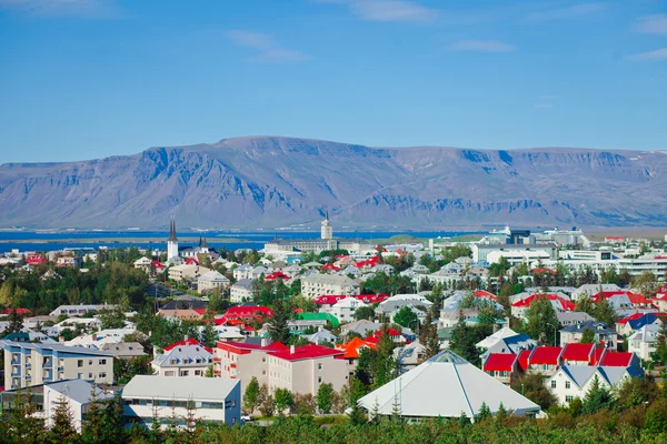 Όμορφη έξοχος Αεροφωτογραφία του Ρέικιαβικ, Ισλανδία με λιμάνι και στον ορίζοντα τα βουνά και τοπίο πέρα από την πόλη, που φαίνεται από την παρατήρηση πύργο της Hallgrimskirkja καθεδρικό ναό. — Φωτογραφία Αρχείου
