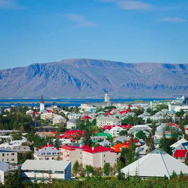 Beautiful super wide-angle aerial view of Reykjavik, Iceland with harbor and skyline mountains and scenery beyond the city, seen from the observation tower of Hallgrimskirkja Cathedral. — Stock Photo, Image
