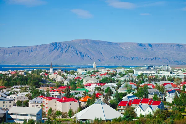 Gyönyörű szuper nagy látószögű légi felvétel a Reykjavik, Izland-kikötő és a skyline a hegyek és a táj túl a város látható a megfigyelő torony a Hallgrimskirkja székesegyház. — Stock Fotó