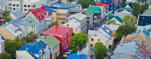 Beautiful super wide-angle aerial view of Reykjavik, Iceland with harbor and skyline mountains and scenery beyond the city, seen from the observation tower of Hallgrimskirkja Cathedral.