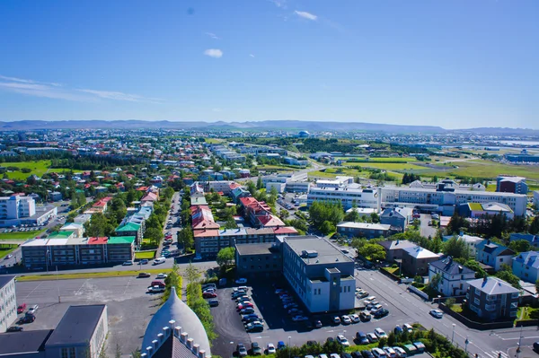 Mooie super groothoek luchtfoto van Reykjavik, IJsland met de haven en de skyline van bergen en het landschap buiten de stad, gezien vanaf de observatie toren Hallgrimskirkja kathedraal. — Stockfoto