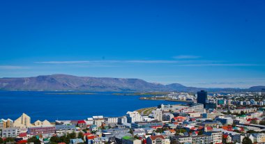 Güzel süper geniş açı havadan görünümü Reykjavik, İzlanda'nın liman ve manzarası dağlar ve şehrin ötesinde gözlem tanımlıkHallgrimskirkja katedral Kulesi gördün.