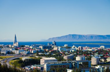 Güzel süper geniş açı havadan görünümü Reykjavik, İzlanda'nın liman ve manzarası dağlar ve şehrin ötesinde gözlem tanımlıkHallgrimskirkja katedral Kulesi gördün.