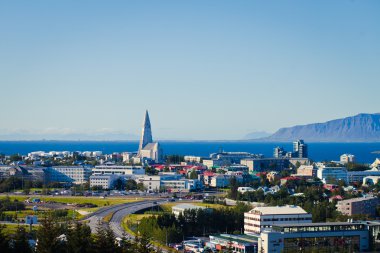 Güzel süper geniş açı havadan görünümü Reykjavik, İzlanda'nın liman ve manzarası dağlar ve şehrin ötesinde gözlem tanımlıkHallgrimskirkja katedral Kulesi gördün.