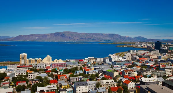 Beautiful super wide-angle aerial view of Reykjavik, Iceland with harbor and skyline mountains and scenery beyond the city, seen from the observation tower of Hallgrimskirkja Cathedral. — Stock Photo, Image