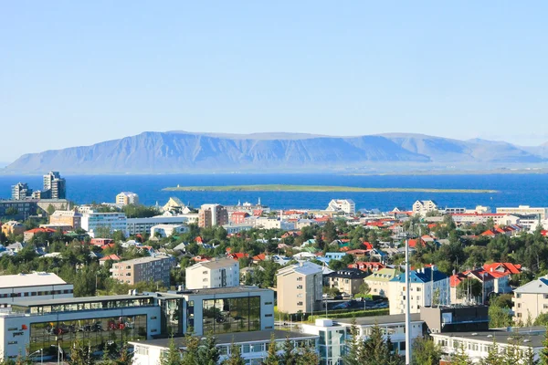 Beautiful super wide-angle aerial view of Reykjavik, Iceland with harbor and skyline mountains and scenery beyond the city, seen from the observation tower of Hallgrimskirkja Cathedral. — Stock Photo, Image