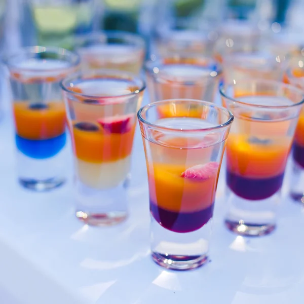 Schöne Reihe von verschiedenen farbigen Cocktails mit Rauch auf einer Weihnachtsfeier, Tequila, Martini, Wodka und andere auf dekorierten Catering-Bouquet-Tisch auf Open-Air-Party — Stockfoto