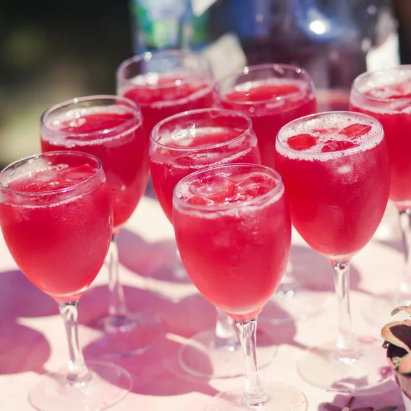 Mooie lijn van verschillende gekleurde cocktails met rook op een kerstfeest, tequila, martini, wodka en anderen op ingerichte catering boeket tafel op open lucht partij — Stockfoto