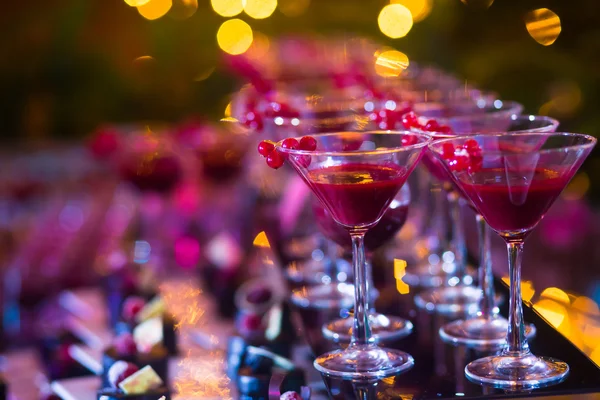 Hermosa línea de cócteles de diferentes colores con humo en una fiesta de Navidad, tequila, martini, vodka y otros en la mesa de ramo de catering decorado en la fiesta al aire libre —  Fotos de Stock