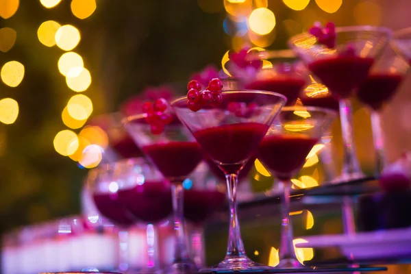 Beautiful line of different colored cocktails with smoke on a Christmas party, tequila, martini, vodka, and others on decorated catering bouquet table on open air party — Stock Photo, Image