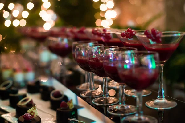 Bela linha de diferentes coquetéis coloridos com fumaça em uma festa de Natal, tequila, martini, vodka e outros na mesa de buquê de catering decorada na festa ao ar livre — Fotografia de Stock