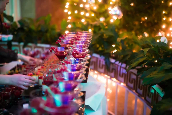 Beautiful line of different colored cocktails with smoke on a Christmas party, tequila, martini, vodka, and others on decorated catering bouquet table on open air party — Stock Photo, Image