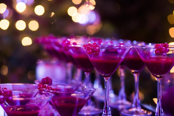 Hermosa línea de cócteles de diferentes colores con humo en una fiesta de Navidad, tequila, martini, vodka y otros en la mesa de ramo de catering decorado en la fiesta al aire libre —  Fotos de Stock