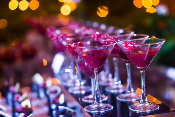 Hermosa línea de cócteles de diferentes colores con humo en una fiesta de Navidad, tequila, martini, vodka y otros en la mesa de ramo de catering decorado en la fiesta al aire libre — Foto de Stock