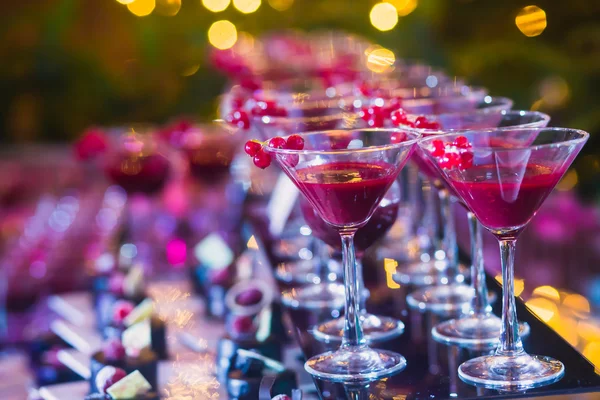 Красивая линия различных цветных коктейлей с дымом на рождественской вечеринке, текила, мартини, водка, и другие на украшенном букетном столе питания на открытом воздухе партии — стоковое фото