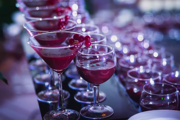 Beautiful line of different colored cocktails with smoke on a Christmas party, tequila, martini, vodka, and others on decorated catering bouquet table on open air party — Stock Photo, Image