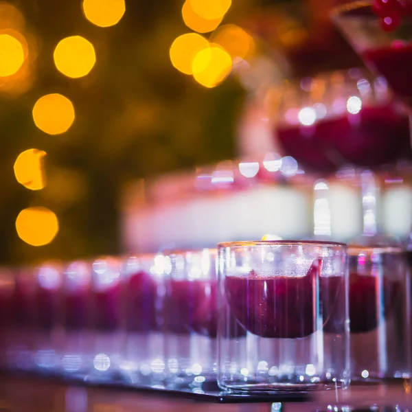 Beautiful line of different colored cocktails with smoke on a Christmas party, tequila, martini, vodka, and others on decorated catering bouquet table on open air party — Stock Photo, Image