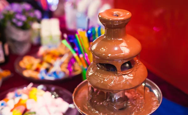 Imagen vibrante de fuente de chocolate en fiesta de cumpleaños de niños con niños jugando y malvaviscos y frutas sumergiéndose en la fuente — Foto de Stock