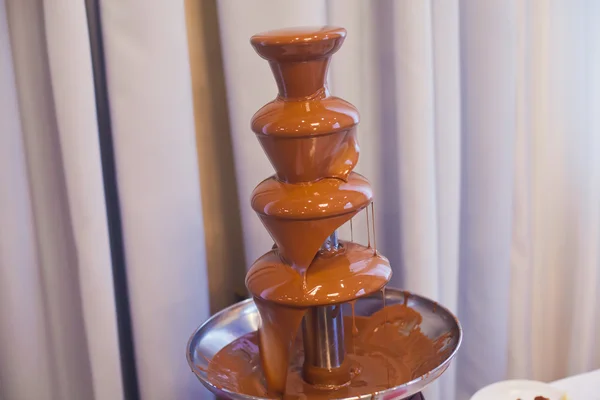 Vibrant Picture of Chocolate Fountain Fontain on childen kids birthday party with a kids playing around and marshmallows and fruits dip dipping into fountain — Stock Photo, Image