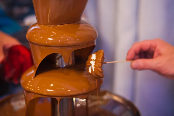 Vibrant Picture of Chocolate Fountain Fontain on childen kids birthday party with a kids playing around and marshmallows and fruits dip dipping into fountain — Stock Photo, Image