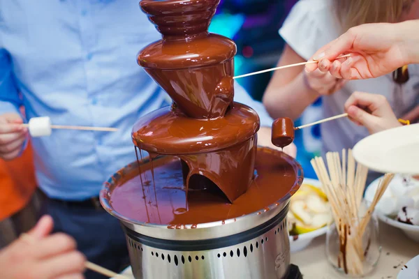 Image vibrante de Fontaine de fontaine de chocolat sur la fête d'anniversaire des enfants avec un enfant jouant autour et des guimauves et des fruits trempant dans la fontaine — Photo